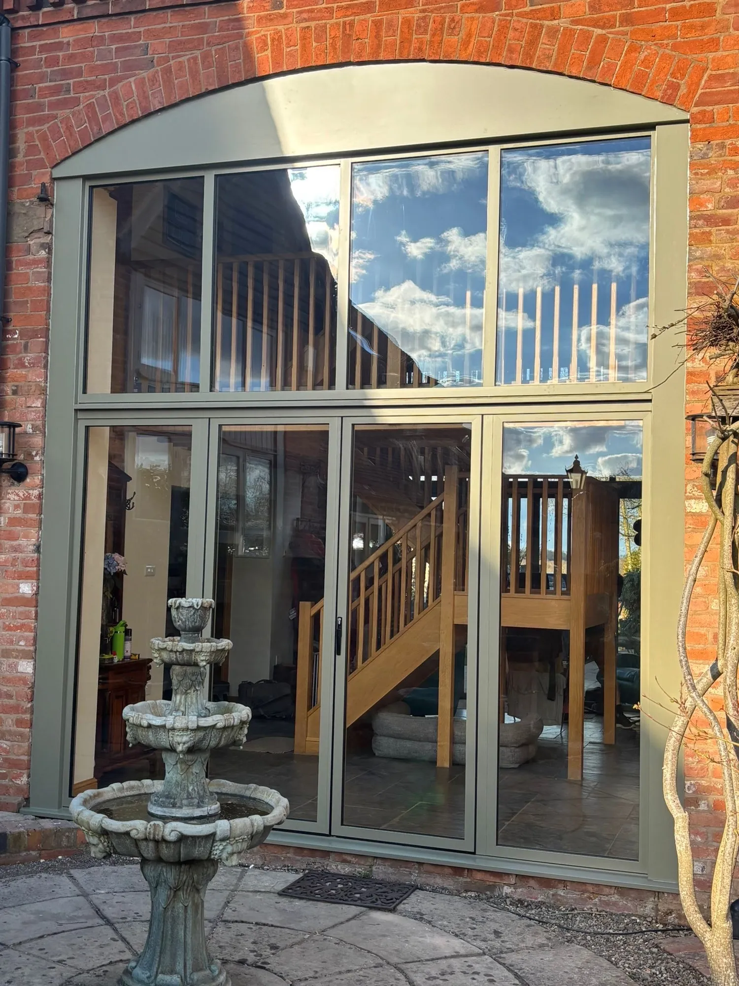Aluminium bifold doors and upper glazing in a brick arch in Redditch