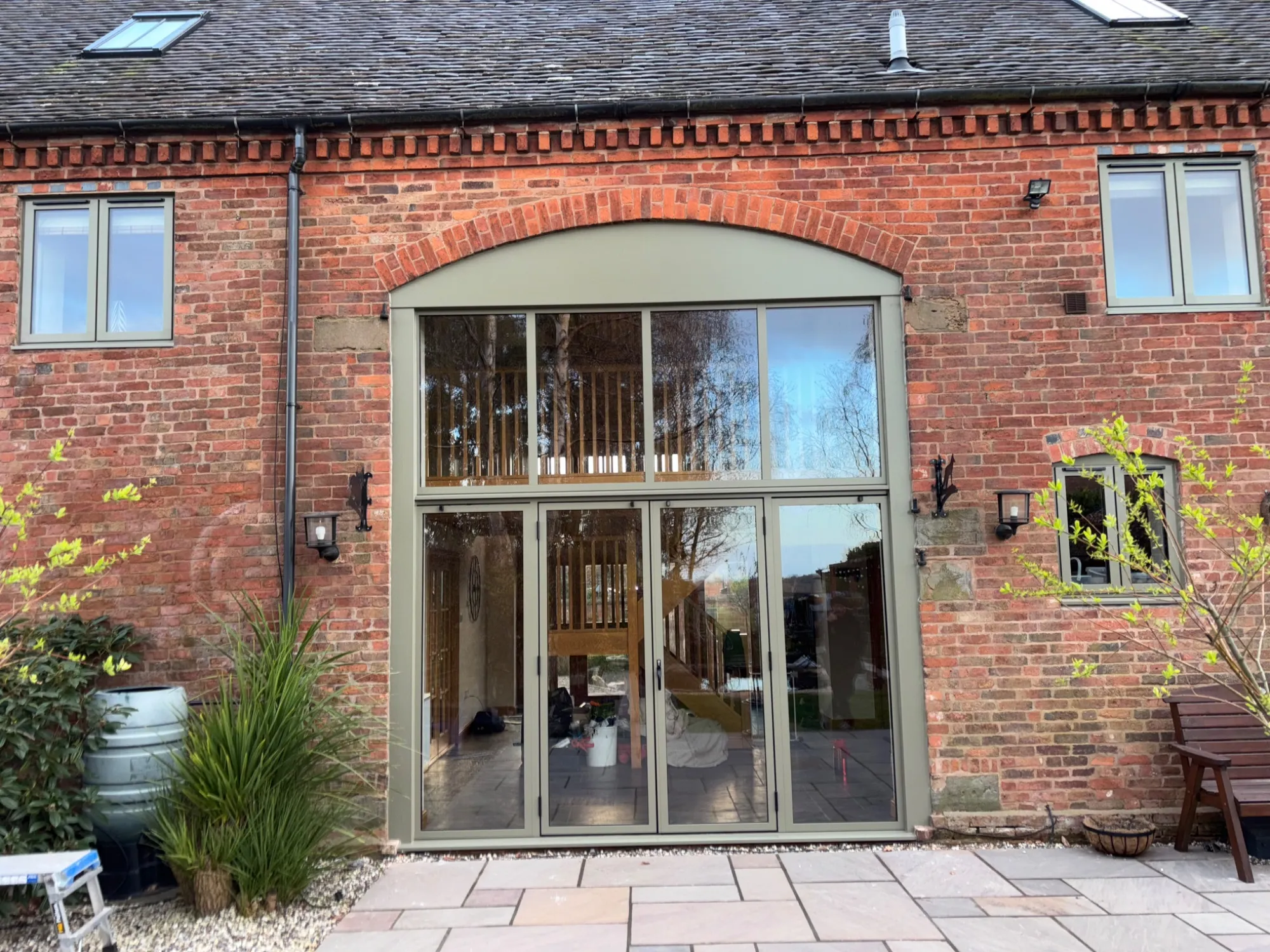Aluminium windows and bifold doors fitted within an arched brick opening in Redditch