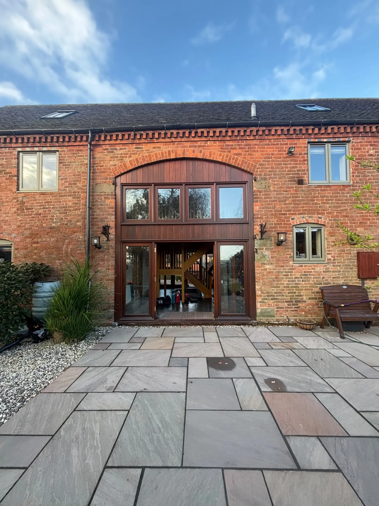 Original timber-framed windows and doors in an arched brick opening in Redditch, before replacement